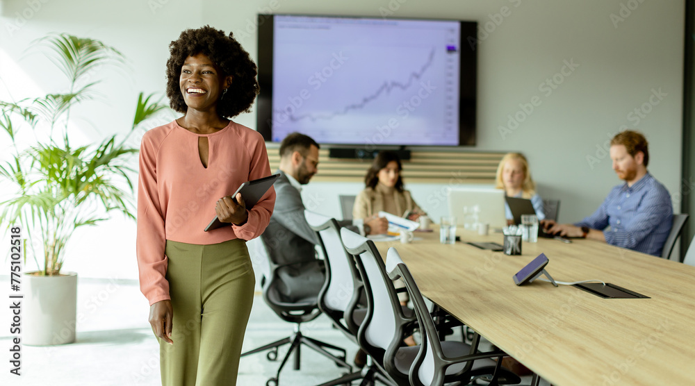 Wall mural radiant african american businesswoman with tablet ready to present in modern conference room