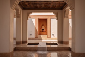 arabic style courtyard with fountain, in beige and orange colors, with intricate tile work and geometric patterns