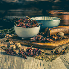 NAGA GHOST CHILLI DRIED PODS on wooden table background. Herbs, spices and dried food baking ingredient. Mortar and different spices. Cottage kitchen. Product Photography