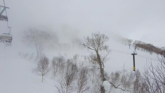 Niseko, Japan: Cinematic landscape on a snowy and foggy day in the famous Niseko ski resort in Hokkaido in winter in northern Japan