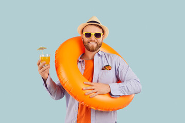 Funny man in inflatable ring holds glass of juice smiling ready for vacation. Vacation readiness...