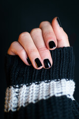 Woman's hand with black nail polish