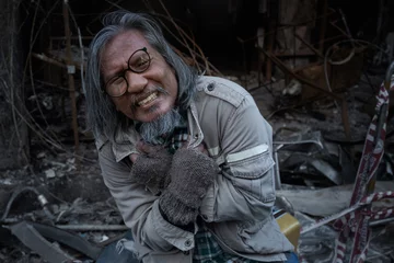 Fotobehang Old man showed signs of madness like a madman when he saw his house destroyed by fire, homeless old man in front of a building destroyed by fire © chomplearn_2001