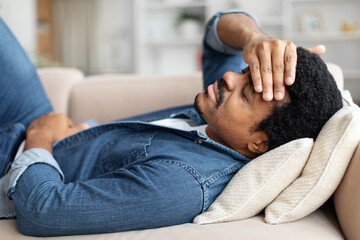 Fototapeta premium Black Man Feeling Unwell At Home, Suffering Stomach Pain And Headache