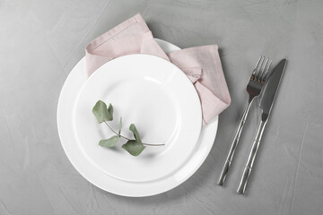 Stylish setting with elegant cutlery on grey table, top view