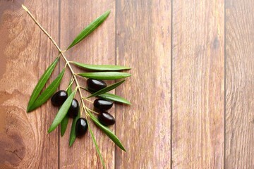 Black olives branch on wooden background photo top view copy space