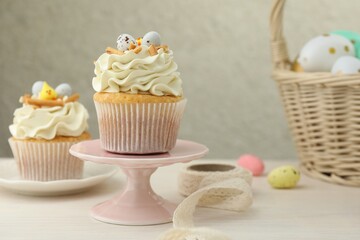 Tasty Easter cupcakes with vanilla cream on light wooden table
