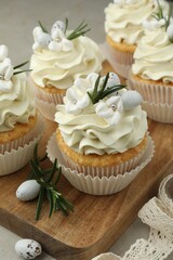 Tasty Easter cupcakes with vanilla cream on table, closeup
