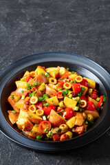 spanish potato salad with chorizo in black bowl