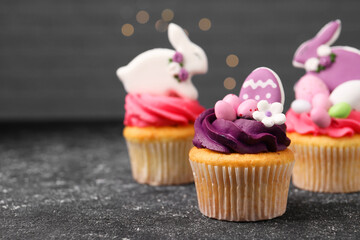 Tasty decorated Easter cupcakes on grey table, space for text