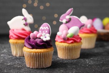 Tasty decorated Easter cupcakes on grey table