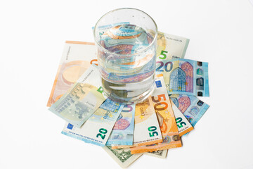 Glass of water on euro banknotes. Payments for water, cost of water concept