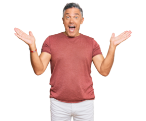 Handsome middle age man wearing casual clothes celebrating victory with happy smile and winner expression with raised hands