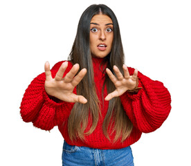 Beautiful hispanic woman wearing casual clothes afraid and terrified with fear expression stop gesture with hands, shouting in shock. panic concept.