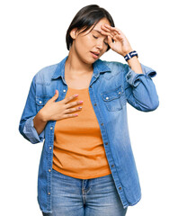Young beautiful hispanic woman with short hair wearing casual denim jacket touching forehead for illness and fever, flu and cold, virus sick