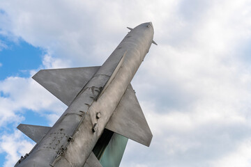 Old Russian gray anti-aircraft missile looking towards the cloudy sky