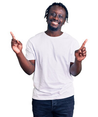 Young african american man with braids wearing casual white tshirt smiling confident pointing with...
