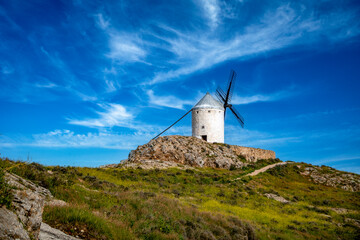 Typical Spanish white windmill on a hill with grass in Consuegra, Toledo, Castilla la Mancha, Spain