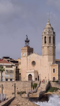 sea church and buildings in sitges, spain in vertical
