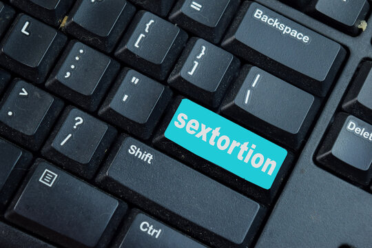Sextortion write on keyword isolated laptop background