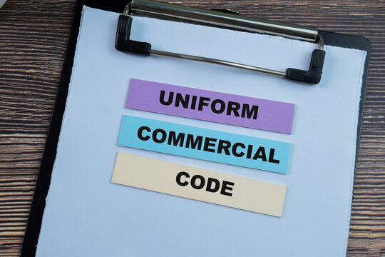 Concept of Uniform Commercial Code write on sticky notes isolated on Wooden Table.