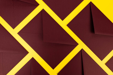 Top view of dark red envelopes on yellow background. Post flat lay. Copy space.