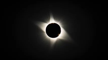 Foto op Plexiglas total solar eclipse viewed from the ground, black sky, white sun corona visible in center of frame, silhouette of moon covering all but its edge © MSTSANTA