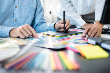 Two creative graphic designer team working on color selection and drawing on graphic tablet, Color swatch samples chart for selection coloring in inspiration to creativity at workplace - 775181169