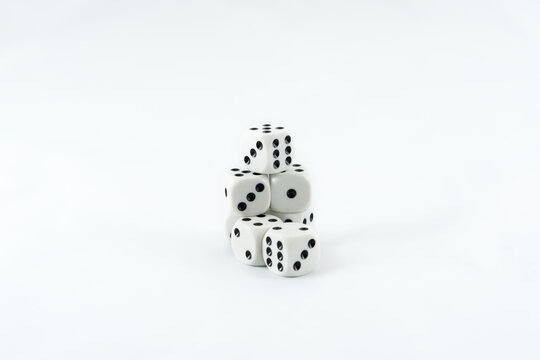 Randomly stacked white dices showing random numbers isolated on white background.