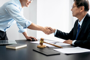 Handshake after good cooperation, Two people shaking hands after discussing contract agreement on front a judge's gavel - 775183128