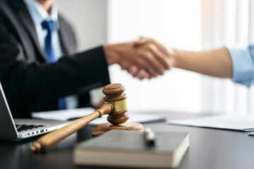 Handshake after good cooperation, Two people shaking hands after discussing contract agreement on front a judge's gavel - 775183171