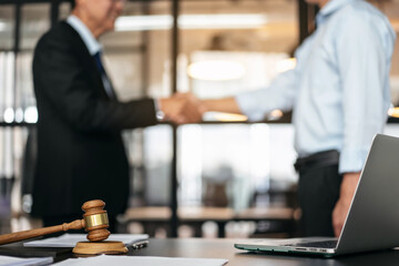 Handshake after good cooperation, Two people shaking hands after discussing contract agreement on front a judge's gavel - 775184542