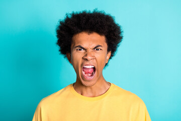 Photo of aggressive mad guy with afro hairdo dressed yellow t-shirt screaming wide open mouth...