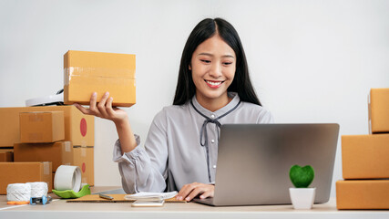 Woman entrepreneur working at home receive orders from online customers and check data while preparing to pack products deliver sending to the client