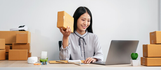 Woman entrepreneur working at home receive orders from online customers and check data while preparing to pack products deliver sending to the client - 775185367
