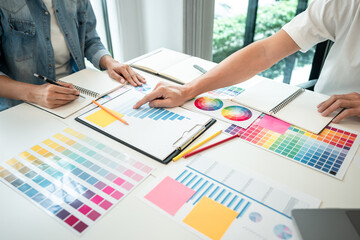 Team of creative graphic designer working on color swatch samples chart for selection coloring in...