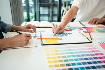 Two creative graphic designer team working on color selection and drawing on graphic tablet, Color swatch samples chart for selection coloring in inspiration to creativity at workplace - 775186521