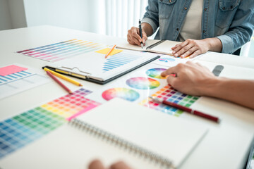 Team of creative graphic designer working on color swatch samples chart for selection coloring in inspiration to create new collection at workplace - 775186724