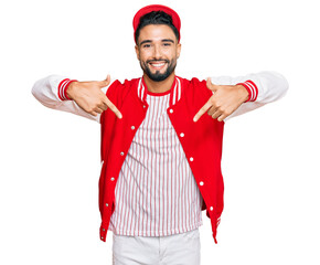 Young man with beard wearing baseball uniform looking confident with smile on face, pointing oneself with fingers proud and happy.