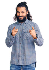 Young arab man wearing casual clothes pointing fingers to camera with happy and funny face. good energy and vibes.