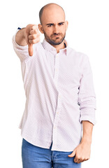 Young handsome man wearing elegant shirt looking unhappy and angry showing rejection and negative with thumbs down gesture. bad expression.