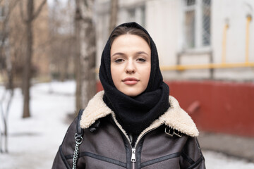 portrait of a young beautiful woman outside wearing a headscarf