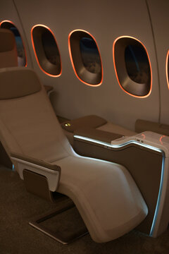 Prototype aircraft with modern hatch-class seats. Beige seats and portholes with lighting. A row with two seats. Vip plane.