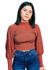 Young brunette woman with blue eyes wearing elegant sweater relaxed with serious expression on face. simple and natural looking at the camera.