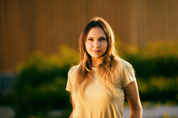 Half-length portrait of young Caucasian woman attractive and slender in light of setting sun in...