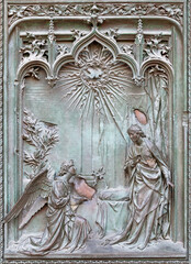 MILAN, ITALY - SEPTEMBER 16, 2024: The detail from main bronze gate of the Cathedral - Annunciation -  by Ludovico Pogliaghi (1906).