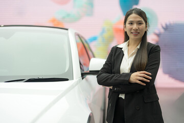 Professional woman standing confidently next to white car