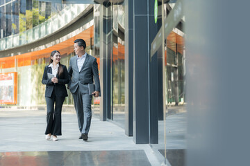 Business colleagues walking together in modern business district - 775232914