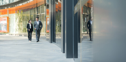 Business colleagues walking together in modern business district - 775232917