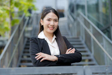Young asian businesswoman smiling at the camera outside the office building